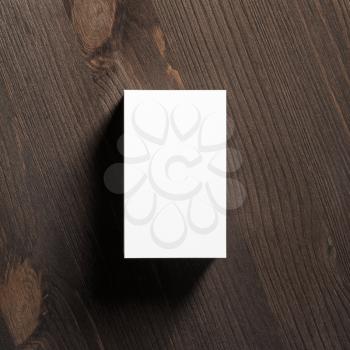 Blank vertical business cards stack on wooden background. Flat lay.
