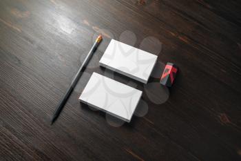 Photo of blank business cards, pencil and eraser on wood table background. Branding mock up.