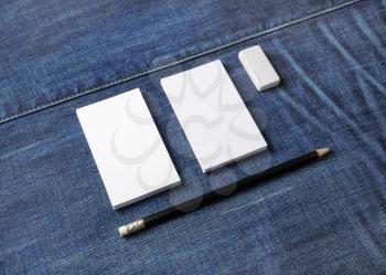 Photo of blank business cards, pencil and eraser on denim background. Stationery mock up. Template for placing your design.