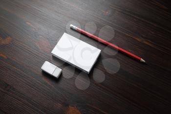 Blank stationery template. White business cards, pencil and eraser on wood table background.