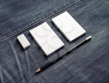Photo of blank white business cards stacks, pencil and eraser on denim background. Stationery mock up.