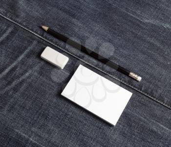 Photo of blank business card, pencil and eraser. Blank stationery set on denim background.