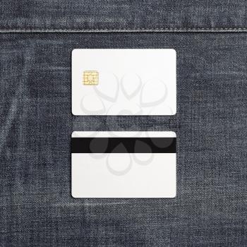 Blank plastic credit cards on denim background. Chip cards. Front and back view. Copy space for text. Flat lay.