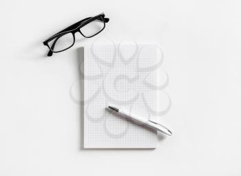 Photo of blank copybook, glasses and pen on paper background. Copy space for text. Flat lay.
