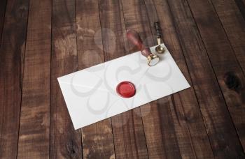 Vintage letter envelope with red wax seal, stamp and spoon on wood table background. Mock-up for your design.