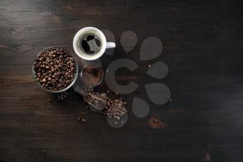 Vintage coffee background. Coffee cup, roasted coffee beans and ground powder on wood kitchen table.. Flat lay.