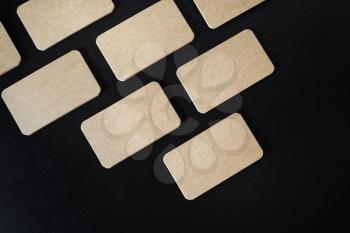 Mockup of kraft business cards on black wood table background. Flat lay.