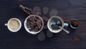 Vintage coffee background. Espresso, coffee cup, roasted coffee beans and ground powder on wooden background. Flat lay.