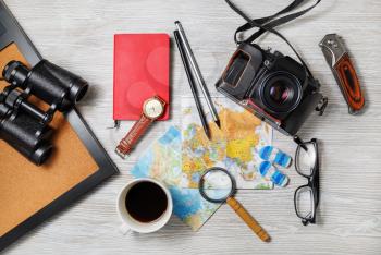Essential travel accessories on light wooden background. Vacation items. Outfit of traveler. Top view. Flat lay.