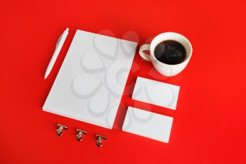 Blank corporate identity template on red paper background. Photo of blank stationery set. Mockup for design presentations and portfolios.