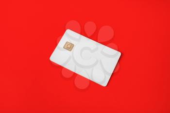 Photo of blank credit card on red paper background. White bank card.