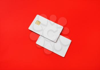 Photo of two blank credit cards on red paper background. White bank cards.