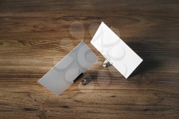 Photo of blank business cards and metal binder clips on wooden background. Responsive design template.