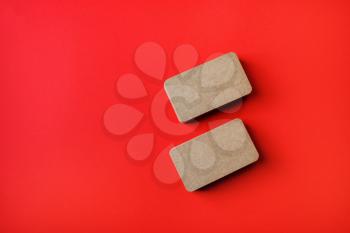 Two blank kraft business cards on red paper background. Branding mockup. Top view. Flat lay.