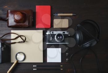 Vintage travel items. Photo of blank stationery and retro camera on wooden background. Flat lay.
