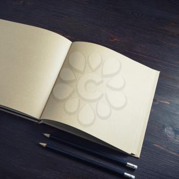 Blank kraft paper booklet or brochure and pencils on wooden background. Copy space for text.