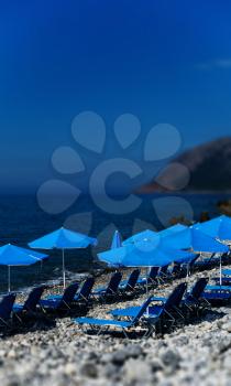 Vertical vivid beach blue umbrellas bokeh background backdrop