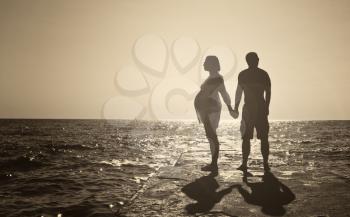 Romantic Couple on a Beach at Sunset on Background.
