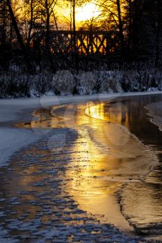 Colorful evening with golden reflection on the winter river