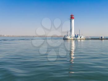 Lighthouse at the entrance to the harbor of the Odessa port, the sea gates of Ukraine in a sunny summer day