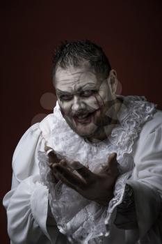 Portrait of a Scary Evil Clown.  Studio shot with horrible face art