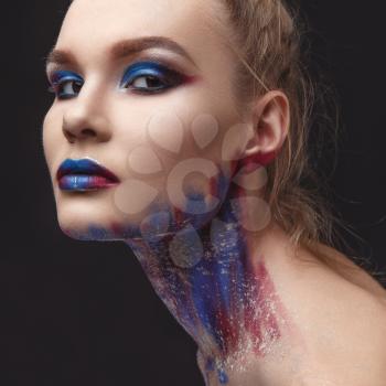 Studio Portrait of a young model girl with stylish makeup in a dark blue tones