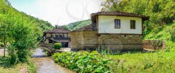 Epiphany Church with a school in the Etar Architectural Ethnographic Complex in Bulgaria on a sunny summer day. Big size panoramic photo.
