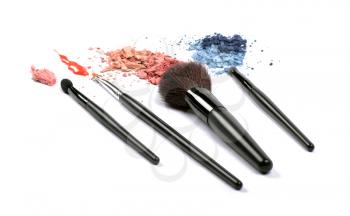 Cosmetic brushes, lip gloss and eyeshadows isolated on white background