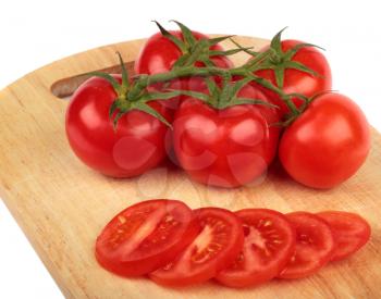 Fresh tomatoes and  tomatoes slices on a hardboard