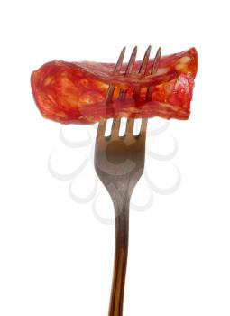 Slice of chorizo sausage on a fork isolated on white background
