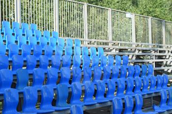 The seats in the stadium. Blue seats in the stands.