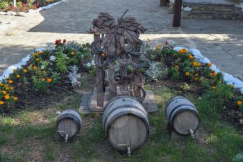 Small flower bed at the court, decorated with barrels of wine. Bunches of grapes, made of horses' hooves and steel.