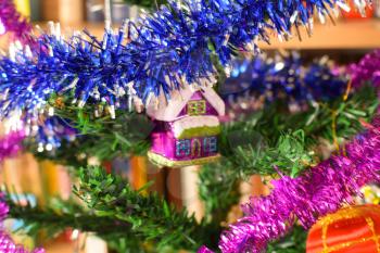 Christmas toys and ornaments on the Christmas tree. Tinsel, balls and toys decorated fir.