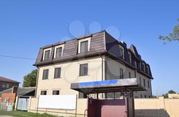 The house with plastic windows and a roof of corrugated sheet. Roofing of metal profile wavy shape on the house with plastic windows.