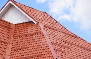 The roof of corrugated sheet red, orange. Roofing of metal profile wavy shape.