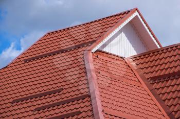 The roof of corrugated sheet red, orange. Roofing of metal profile wavy shape.