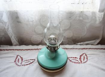 Kerosene lamp on the table near the window.