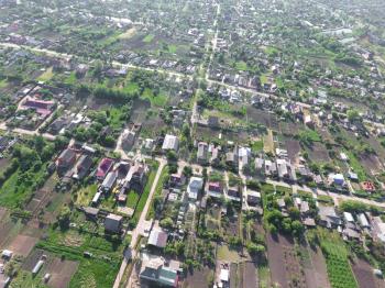 Top view of the village. One can see the roofs of the houses and gardens. Road and water in the village. Village bird's-eye view.