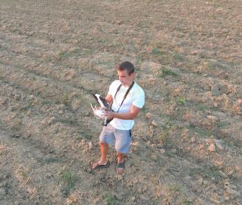 The man is holding a remote control from the quadrocopters. Photographer's work with gadgets.