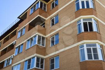 Balconies and windows of a multi-storey new house. New house of brick.