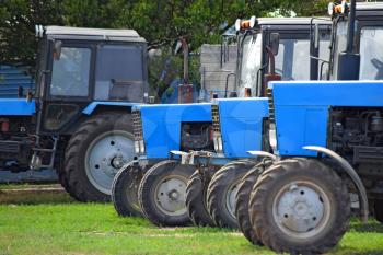 Tractor, standing in a row. Agricultural machinery. Parking of agricultural machinery.