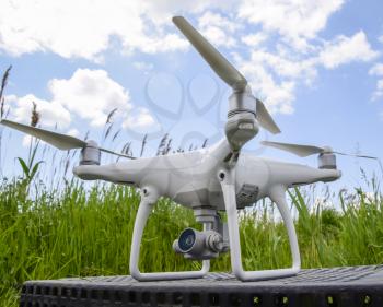 Quadrocopters on a plastic box in the grass. Preparation quadrocopter to fly.