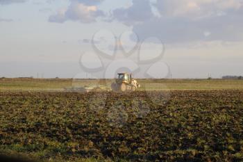 Tractor plowing plow the field. Tilling the soil in the fall after harvest. The end of the season.