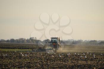 Tractor plowing plow the field. Tilling the soil in the fall after harvest. The end of the season.