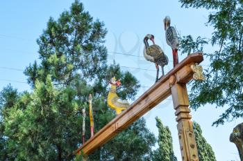 Wooden figures of birds on a wooden arch. Woodcarving Art.