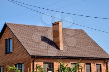 Detached house with a roof made of steel sheets. Roof metal sheets. Modern types of roofing materials.