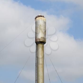 Stork on a roof of a water tower. Stork nest.