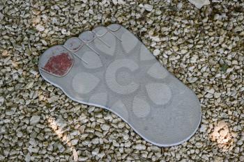 Tile in the form of foot of the person. A footpath in park.