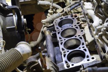 The cylinder block of the four-cylinder engine. Disassembled motor vehicle for repair. Parts in engine oil. Car engine repair in the service.