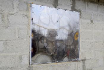 A window made of plexiglas in a concrete wall. A window with a reflective sticker